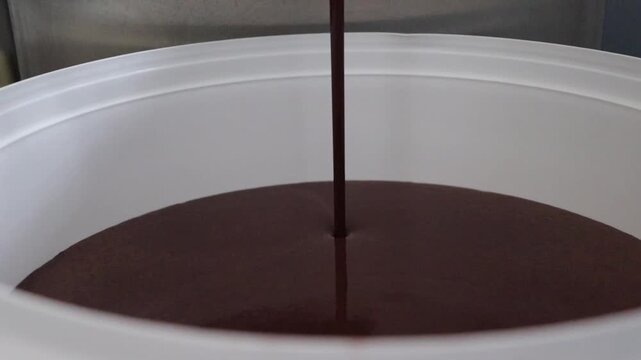 Pouring Milk Chocolate Ice Cream Base into a Food Bucket