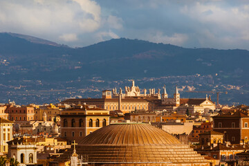 Rome historic center panoramic view with Patheon ancient dome, St John Basilica and mountains in the background