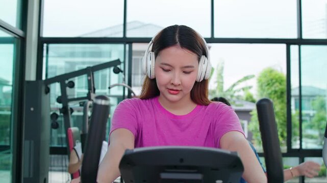 Woman Using Outdoor Rowing Machine In Park