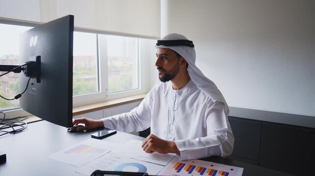 Men with dish dasha working in business office of Dubai. Portraits of  successful businessmen in traditional emirates white dress. Concept about middle eastern cultures.	