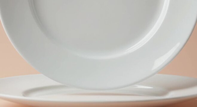Two plain white ceramic plates stacked on light background