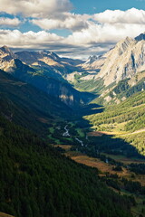 Fototapeta premium Val d'Aosta, Italy - August 15, 2025: High angle view of Val Veny valley and the debris-covered Miage Glacier under a dramatic sky on the Tour du Mont Blanc (TMB).
