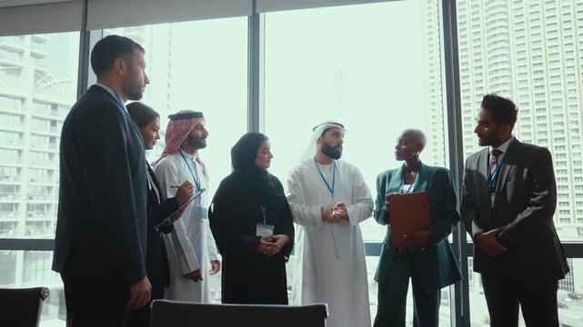 Western and emirati businesspeople in traditional arab attire participating in a conference with ceo, collaborating and taking notes in modern office environment