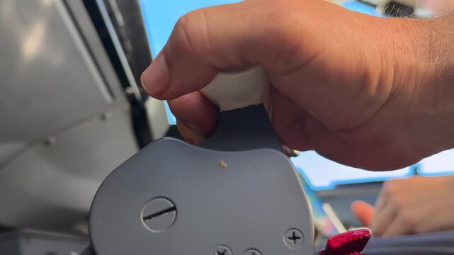 close-up view, low angle, of the hand of a caucasian pilot adjusting the thrust levers in a real flight.