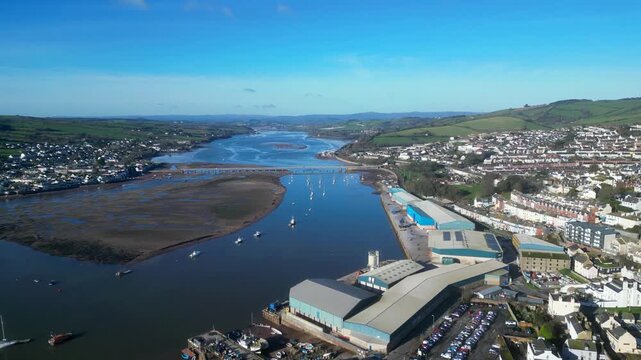 Teignmouth, South Devon, England: DRONE VIEWS: Riverside wharves of Teignmouth Docks (blue buildings); Shaldon bridge over the River Teign. Teignmouth is a UK holiday destination and port.