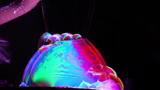 Colorful bubbles form and pop during a science demonstration in a lab