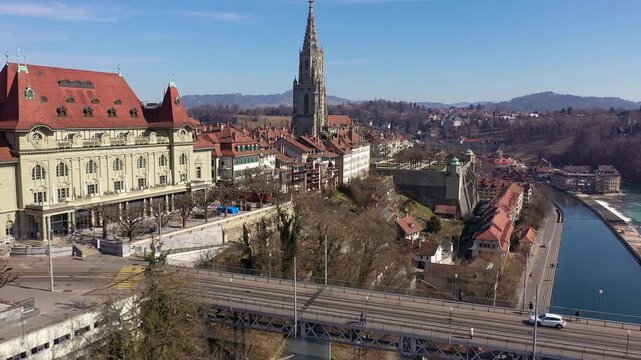 Bern, Switzerland: Aerial drone footage of the riverfront view of the Bern medieval old town by the Aar river with the gothic Berne cathedral in Switzerland capital city on a sunny day