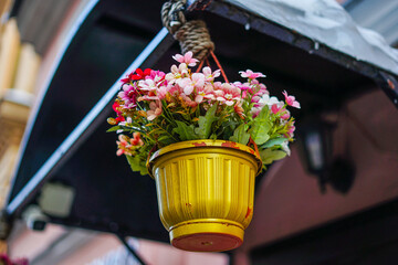 Colorful Artificial Flowers in a Hanging Yellow Pot