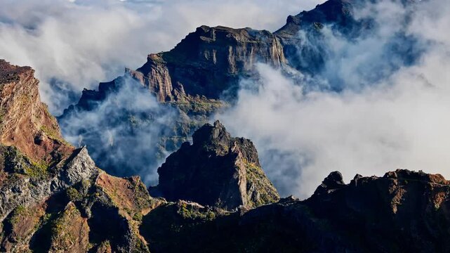 Thick clouds moving between sharp mountain formations near Pico do Arieiro, Madeira, aerial view