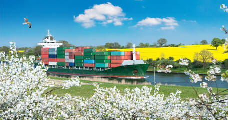 Spring landscape with cherry blossom and rapeseed blossom as well as a container ship on a canal  © Wolfgang Jargstorff