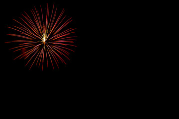 夜に光り輝く赤い花火（左）