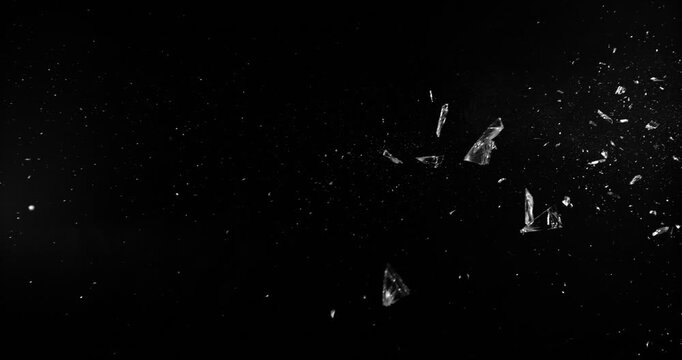 Super slow motion bullet impact shattering glass filmed at 1000fps. Side view of gunshot breaking window with flying shards and dust isolated on black background. Perfect VFX overlay element.