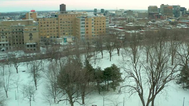 drone flying over lake in park lafointaine montreal winter fron notre dame hospital to main building in the middle of parc