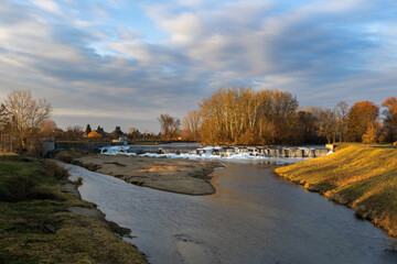 Winter weir at Cvrcovice with ice cascades in warm light. Long exposure creates a silky water effect amidst a frozen natural landscape. © Jana Krizova
