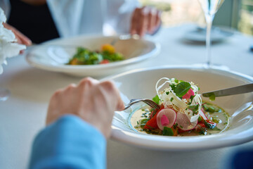 Close up of two female friends eating delicious food in cafe