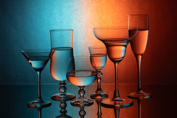 Six glass goblets on a colored gradient background