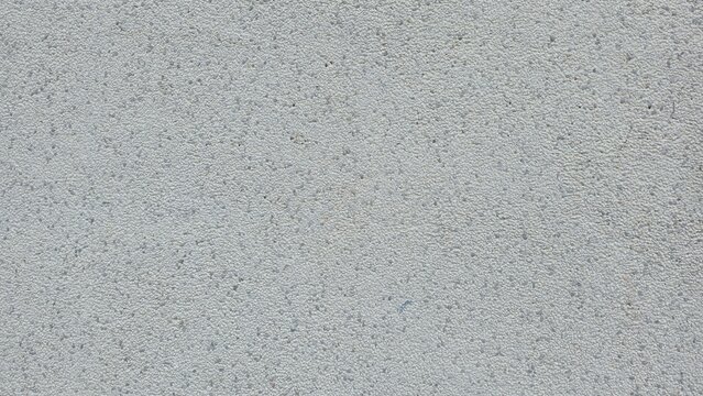 Grey sandblasted granite stone texture background. Fine speckled texture of a sandblasted grey granite surface. Ideal for architectural backgrounds, construction materials, and minimalist designs.
