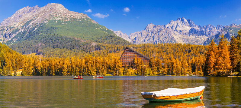 &Scaron;trbsk&eacute; Pleso (Strbske Pleso) in the High Tatras, Slovakia, with a panoramic view of a mountain lake surrounded by vibrant autumn foliage. Crystal clear water, dramatic sky, and majestic alpine peaks 