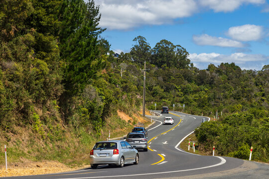 Cars heading uphill on a typically winding road on the Coromandel Peninsula, New Zealand