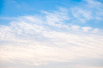 Naklejka premium Beautiful blue sky background with soft white clouds and natural morning sunlight. Bright heaven landscape for summer seasonal design, weather forecast, and spiritual concept
