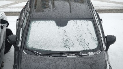 Ośnieżony samochód na parkingu w okresie zimowym