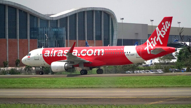 Airplane Air Asia Airbus A320-200 Taxiing on Runway Near GMF AeroAsia Maintenance Hangar on December 2, 2025 in Soekarno-Hatta Interational Airport, Jakarta, Indonesia