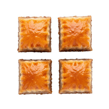 Four square pieces of caramelised honeycomb toffee on a white background.