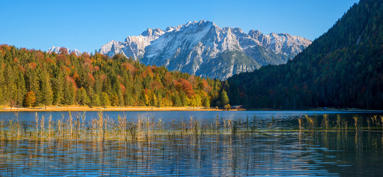 autumnal idyll lake Ferchensee, colorful forest and Karwendel alps view, upper bavaria