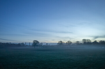 Misty field under blue dawn sky