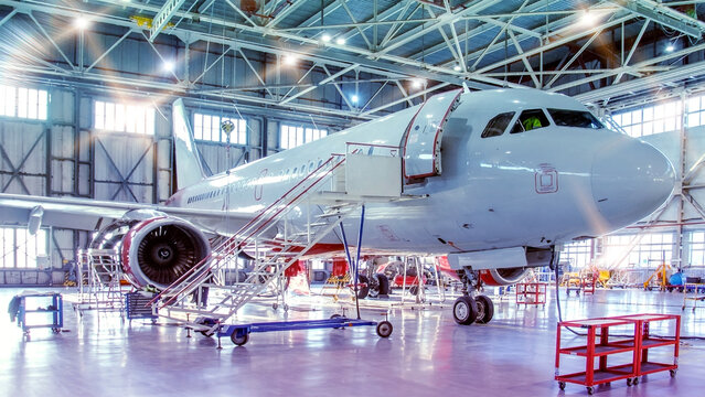 Maintenance and repair of aircraft in the aviation hangar of the airport, flash stars lights bright