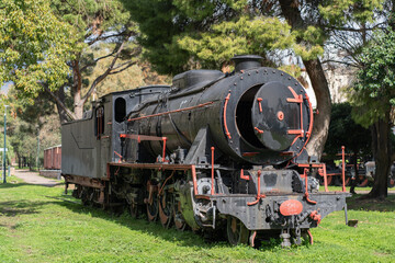 Naklejka premium Well-preserved historic locomotive photographed outdoors in Greece under clear daylight.