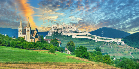 Spi&scaron; Castle (Spi&scaron;sk&yacute; hrad) in Slovakia, a historic stone fortress perched on a hilltop, with panoramic views of the surrounding mountains. Dramatic sky, vibrant colors, and natural light highlight the