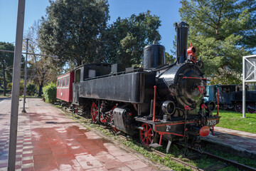Obraz premium Well-preserved historic locomotive photographed outdoors in Greece under clear daylight.