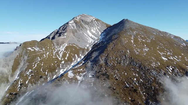 Aerial Drone View of Mount Stol in Slovenia on a Sunny Day with Snow Patches