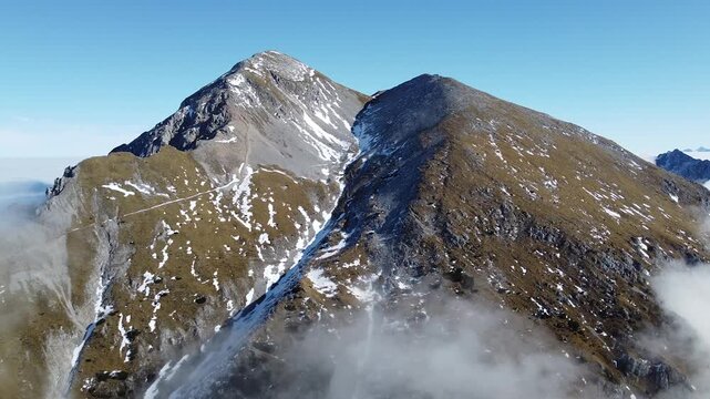 Aerial drone flight over Mount Stol (Hochstuhl) ridge in Slovenia, alpine landscape with snow patches