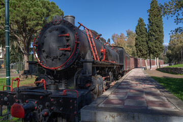 Well-preserved historic locomotive photographed outdoors in Greece under clear daylight. © Tomas Bazant