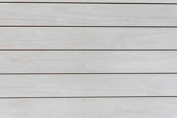 Obraz premium A white wooden wall with a pattern of lines. The lines are spaced evenly apart. The wall is very plain and simple