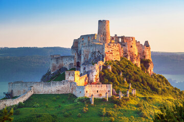 Obraz premium Spiš Castle (Spišský hrad) in Slovakia, a historic stone fortress perched on a hilltop, with panoramic views of the surrounding mountains. Dramatic sky, vibrant colors, and natural light highlight the