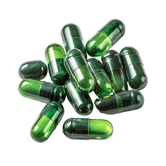 Pile of translucent green capsules on a white background