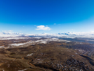 Fototapeta premium A large, empty, snow-covered plain with a few houses in the distance