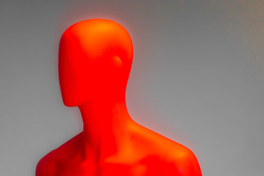 Primo piano di un manichino rosso su sfondo neutro