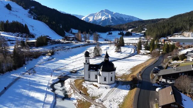 perspective sprawling alpine town seefeld mix modern hotels traditional chalets framed by majestic jagged limestone peaks karwendel wide drone tirol austria 