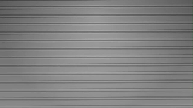 A gray metal rolling shutter door closes and opens against a bright green screen background