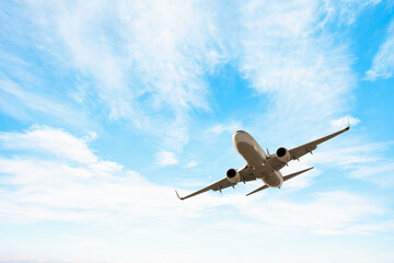 Obraz premium White passenger airplane flying in the sky amazing clouds in the background - Travel by air transport