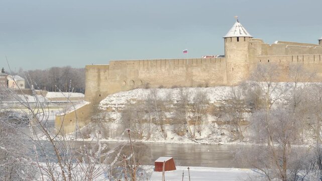 Narva, Estonia &ndash; February 2026: Morning mist rising over the Narva River near the historic Ivanogorod Fortress on the Russia&ndash;Estonia border during winter sunrise.