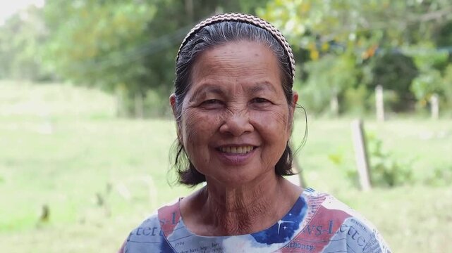 Old asian woman senior female portrait outdoor smiling elderly lady face closeup natural light with wrinkles and headband casual clothing rural