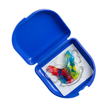 Open purple retainer case holds colorful orthodontic plate on isolated on white or transparent background, for daily storage and hygienic care.