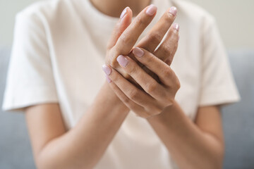 Fototapeta premium Health care and medical concept, rheumatism asian woman hand pain from cramp, trigger finger, wrist pain touching massaging, hand holding ache joint, arthritis inflammation.Chronic disease from injury