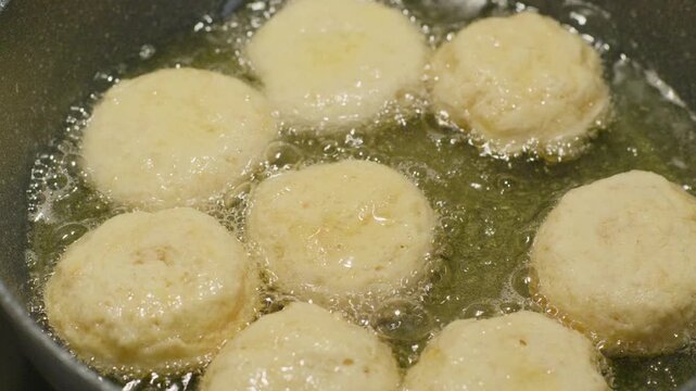 Detail of European made healthy doughnuts frying in a pan with hot oil