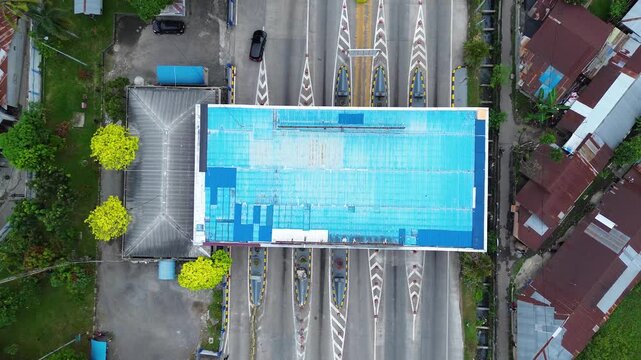 Symmetrical toll gate plaza and highway traffic infrastructure in Southeast Asia Indonesia seen from above, aerial